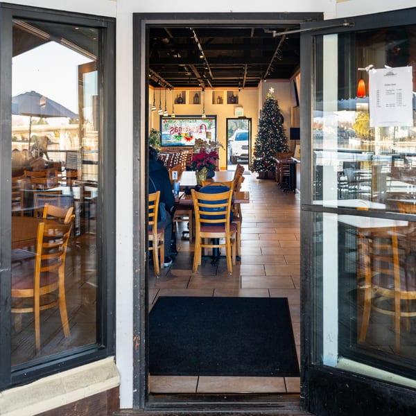 Entrance to Waterfront Pizza restaurant, with a Christmas tree and holiday decorations inside.